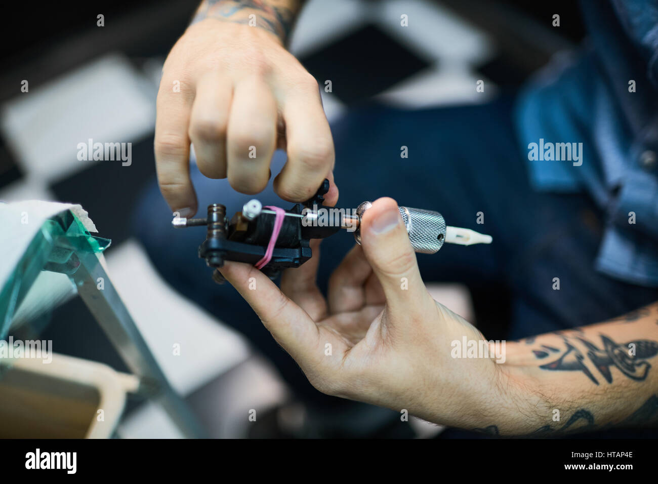 Hände des Meisters halten Tattoo-Maschine Stockfoto