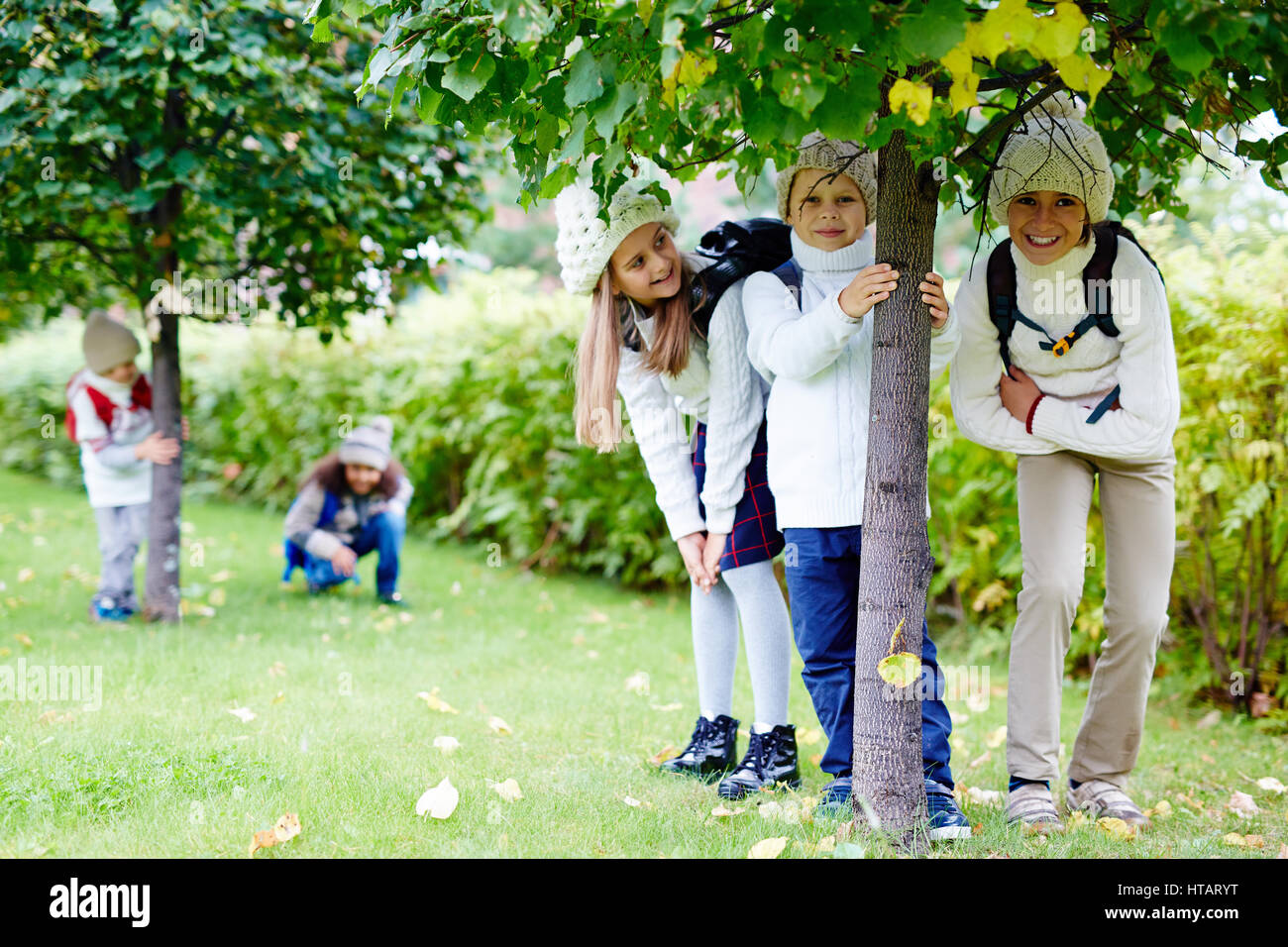 Gruppe von freundlichen Kindern stehen unter den Linden Stockfoto