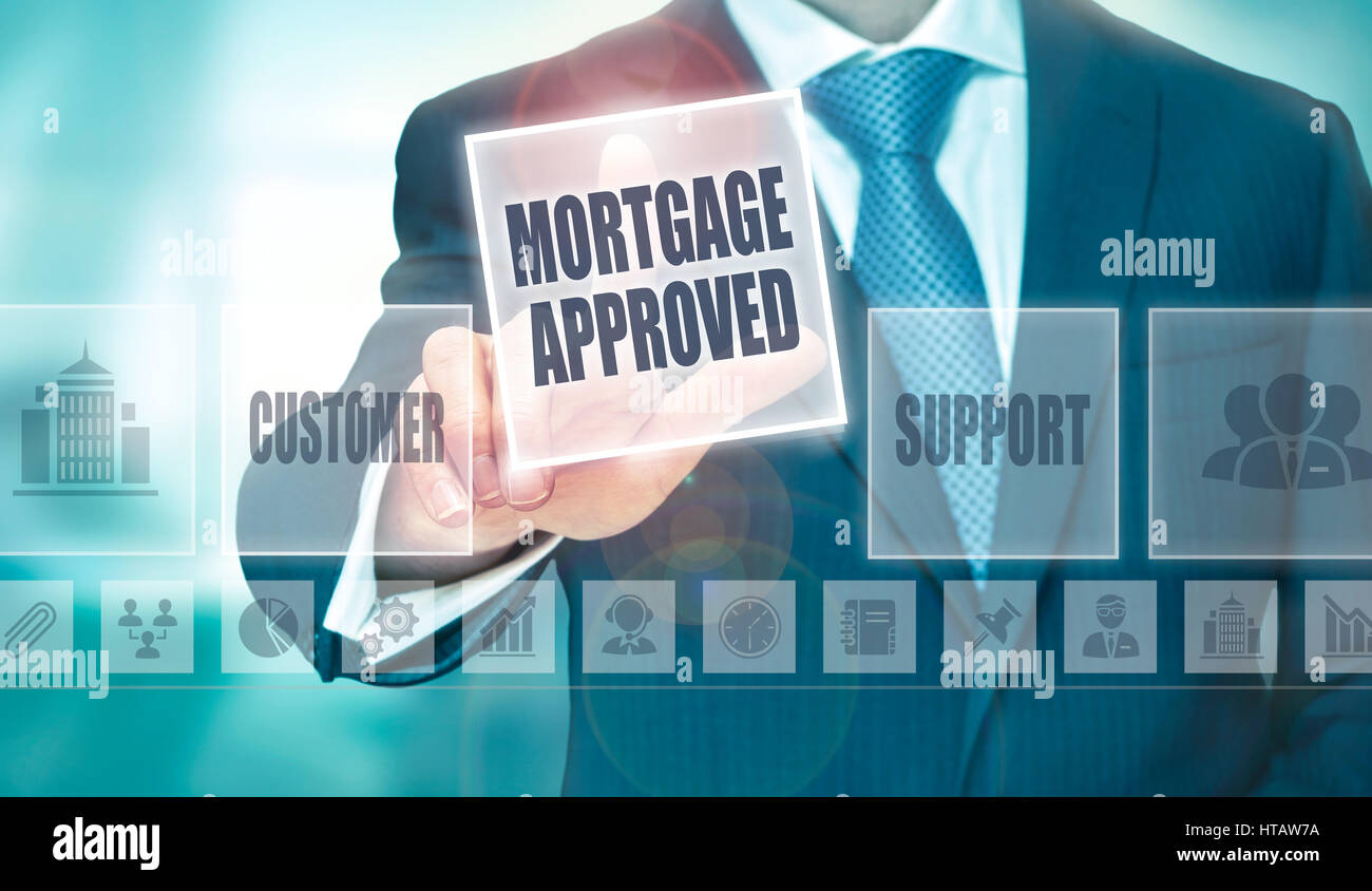Ein Geschäftsmann auf Knopfdruck Hypothek genehmigt auf einem transparenten Bildschirm. Stockfoto