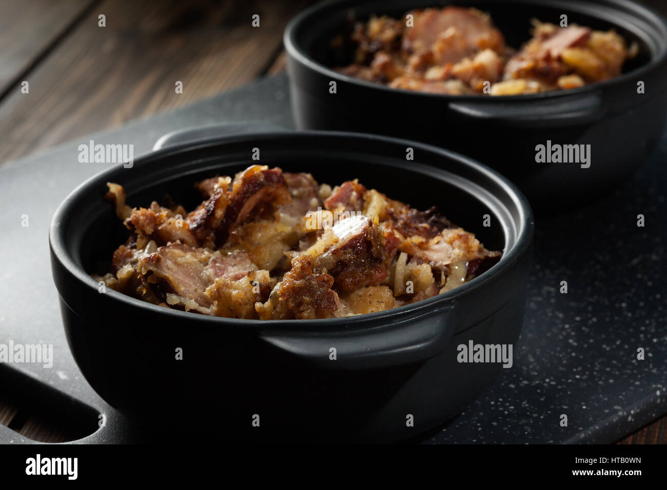 Kartoffeln überbacken mit Wurst und Speck. mystisches Licht Stockfoto