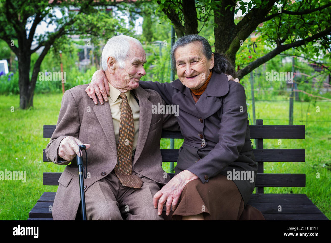 Süße 80 Jahre altes Ehepaar posieren für ein Portrait in Ihren Garten. Liebe ewig Konzept. Stockfoto