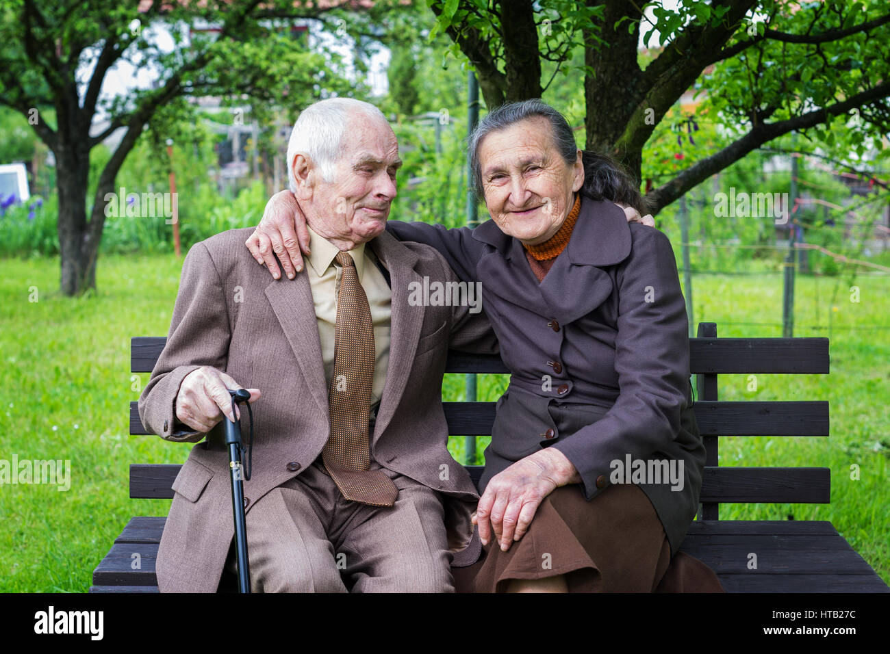 Süße 80 Jahre altes Ehepaar posieren für ein Portrait in Ihren Garten. Liebe ewig Konzept. Stockfoto