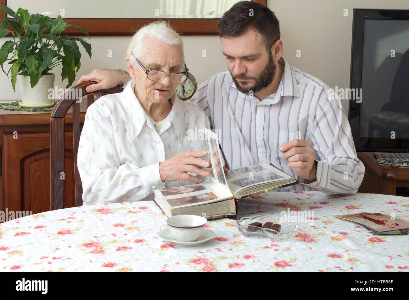 Großmutter mit Enkel erinnern alte Zeiten beobachten Fotoalbum.  Enkel Omas Fotoalbum zeigen. Familientreffen. Stockfoto