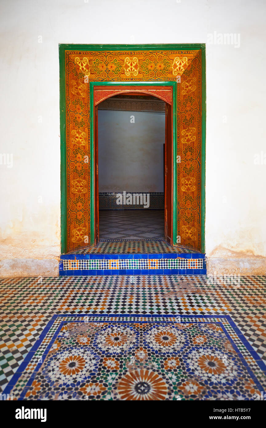 Berber Arabesken bemalte Holztür Surround und Zellige Fliesenboden. Die Petite Gericht, Bahia-Palast, Marrakesch, Marokko Stockfoto