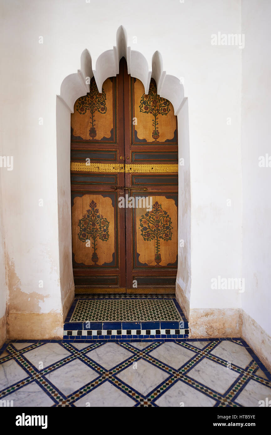 Berber Arabesken bemalte Holztür und Zellige Fliesenboden. Die Petite Gericht, Bahia-Palast, Marrakesch, Marokko Stockfoto