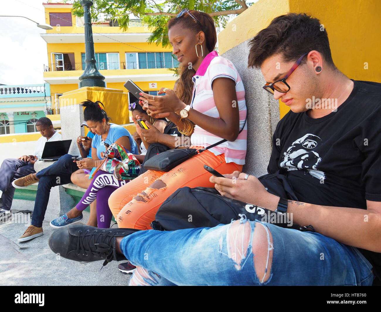 Junge Kubaner in Santiago De Cuba Marti Plaza konzentriert sich auf die Verwendung von Smartphones. Stockfoto