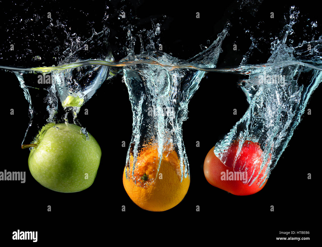 Spritzwasser aus Früchten Droping in dem klaren Wasser Stockfoto