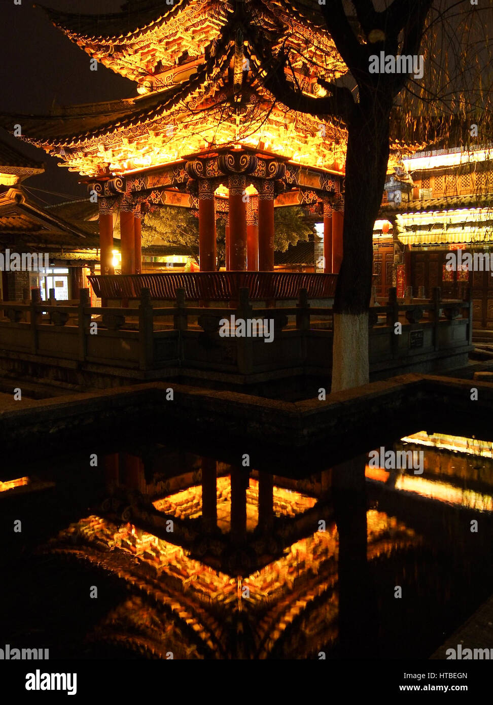 Eine Pagode ist in der Nacht in Dali, China mit der traditionellen Struktur spiegelt sich in kleinen Teich beleuchtet. Stockfoto