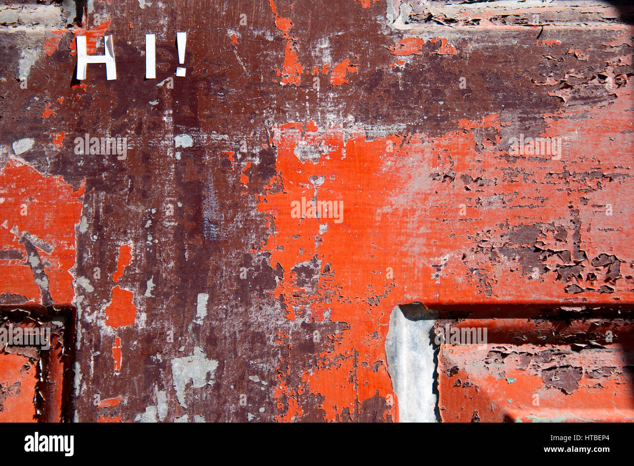 Das Wort "Hallo!" wurde Recherchen auf diese alte, verwitterte, rote Tür. Stockfoto