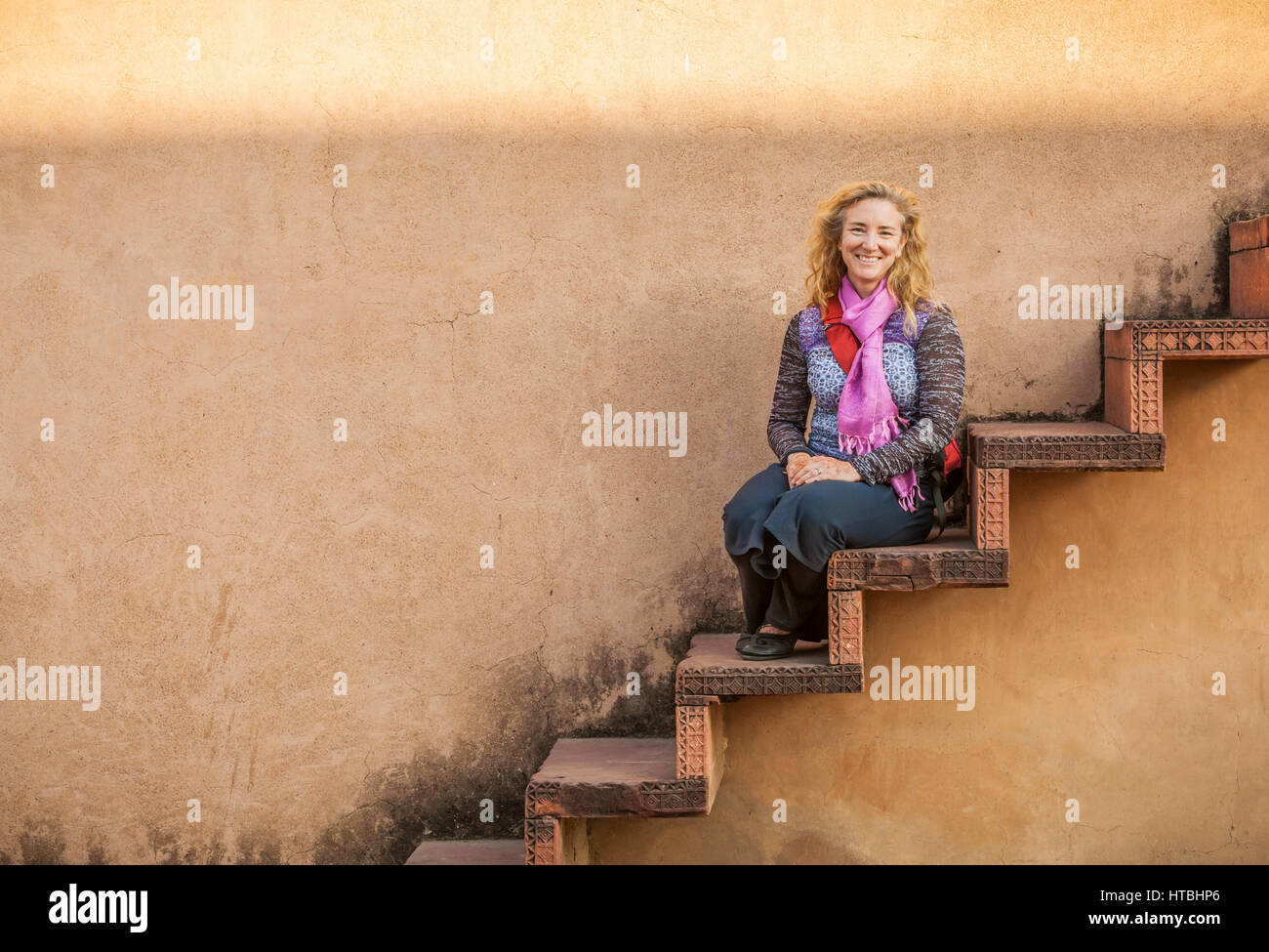 Porträt einer Frau auf einer Treppe, Fatehpur Sikri, Indien. Stockfoto