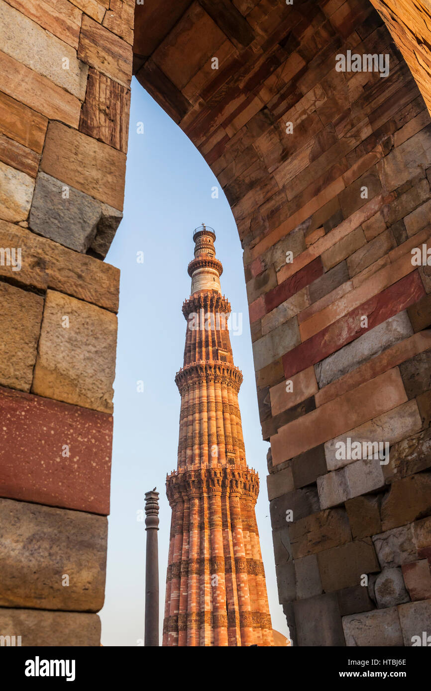 Eiserne Säule von Delhi gesehen mit Qutub Minar durch einen gemauerten Torbogen, Qitb Komplex, Delhi, Indien. Stockfoto