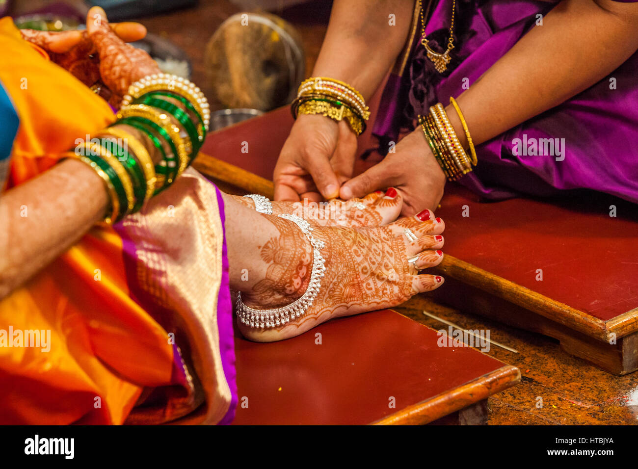 Platzieren Ringe an den Zehen der Braut in einer Hindu-Hochzeit, Pune, Indien. Stockfoto