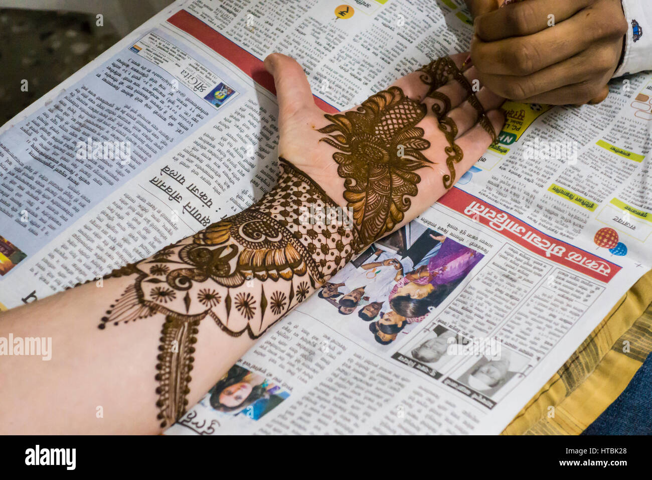 Henna von einem Mehndi-Künstler in der Vorbereitung für eine Hochzeit auf einem Womans Arm, Hand und Finger angewendet wird. Pune, Indien. Stockfoto