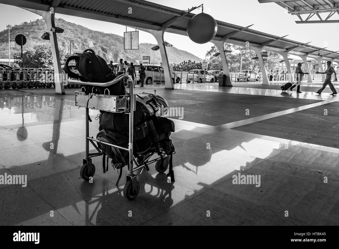 zwei Menschen treffen an einem Flughafen terminal mit Gepäck im Vordergrund Stockfoto