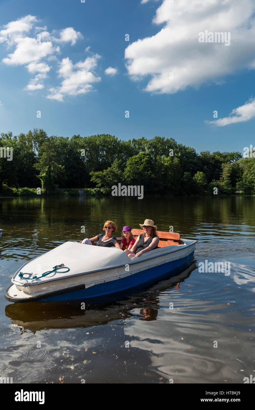 Zwei Frauen und ein Mädchen auf einem Tretboot auf ein ruhiger Fluss, umgeben von dichten Wäldern an einem sonnigen Tag; Steinbrucker Teig, Hessen, Deutschland Stockfoto