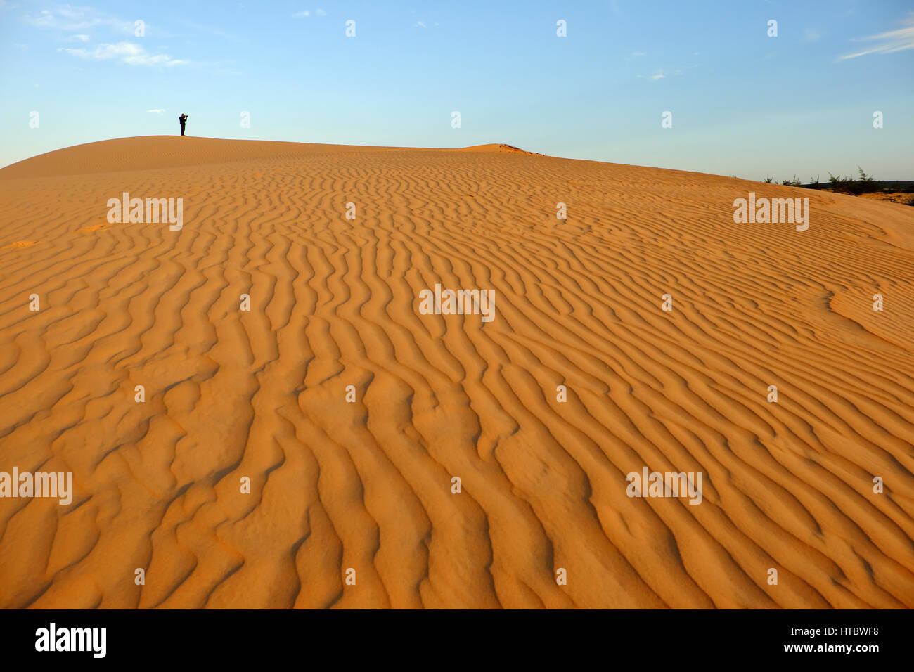 Erstaunliche Form auf vietnamesische Sand Hill auf der bau Trang, Mui Ne, Vietnam. einsamer Mann zu Fuß am Sandstrand Foto, wunderschöne Landschaft für den Sommer Reise zu nehmen Stockfoto