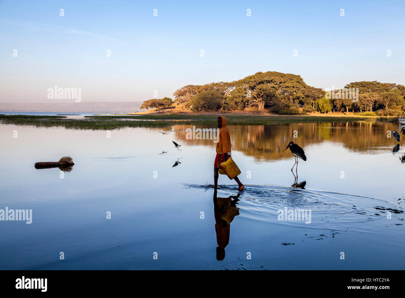 Ein Teenager sammelt Wasser aus dem See In Containern, See Awassa, Äthiopien Stockfoto