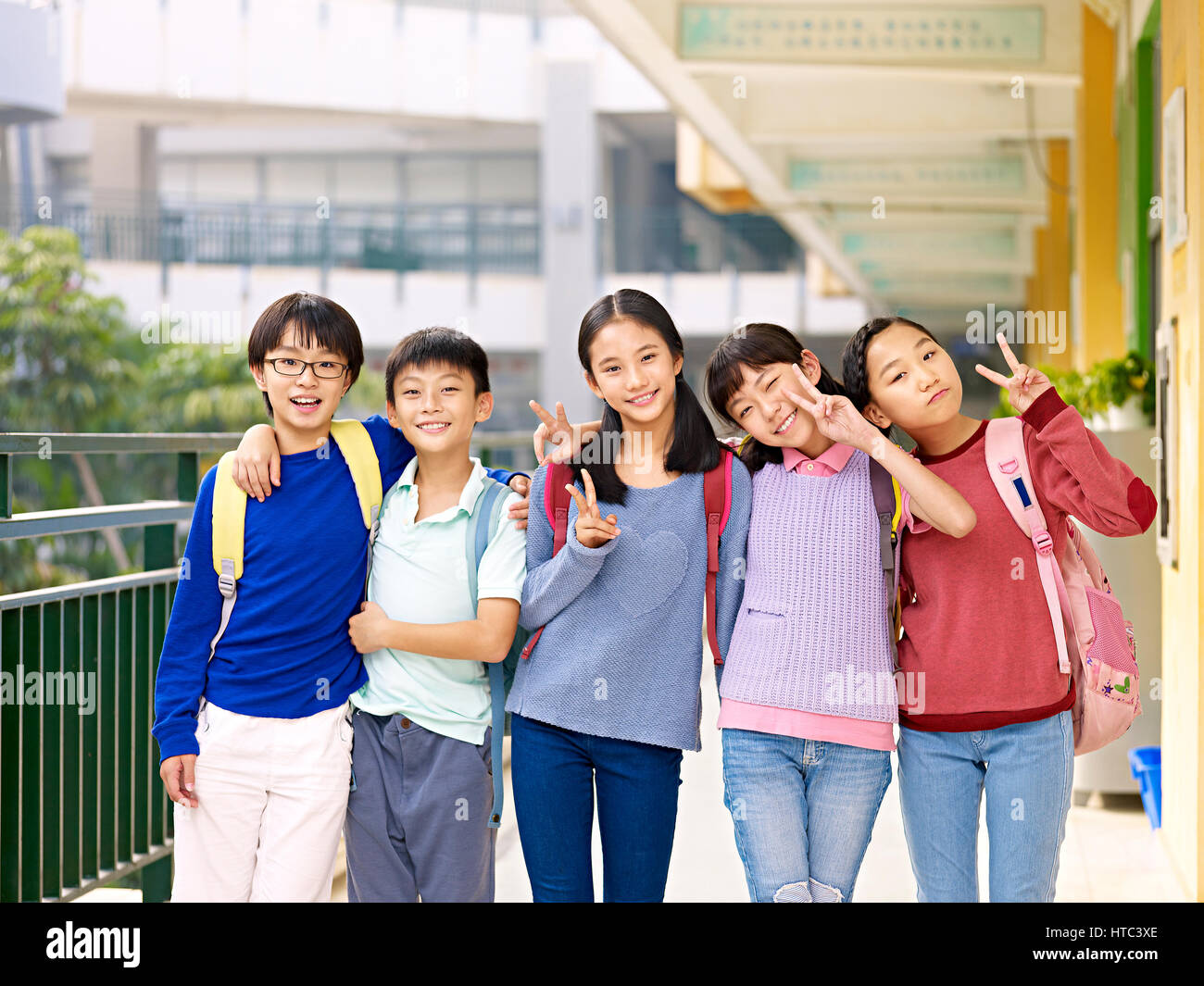 Gruppe von glücklich lächelnde Grundschule Schüler posiert auf Korridor von Unterrichtsgebäude. Stockfoto