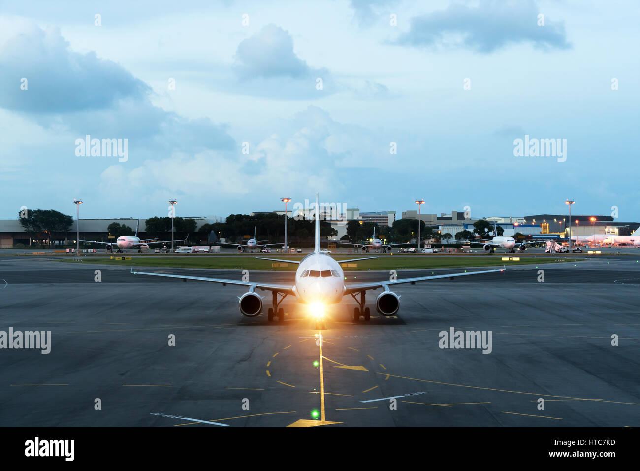Weiße Passagierflugzeug startet von der Landebahn des Flughafens. Flugzeug bewegt sich vor dem Hintergrund der Nacht. Flugzeug-Vorderansicht. Stockfoto