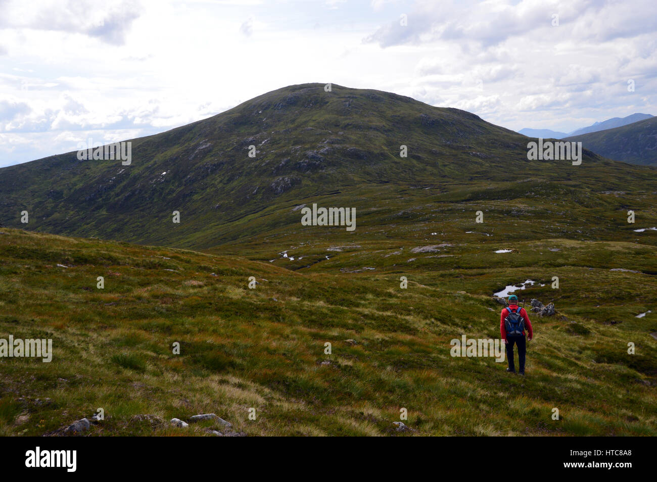 Eine einsame männliche Hillwalker auf dem Grat zwischen der schottischen Berge Corbet des Meall Na h-Eilde und Geal Charn in den schottischen Highlands. Stockfoto