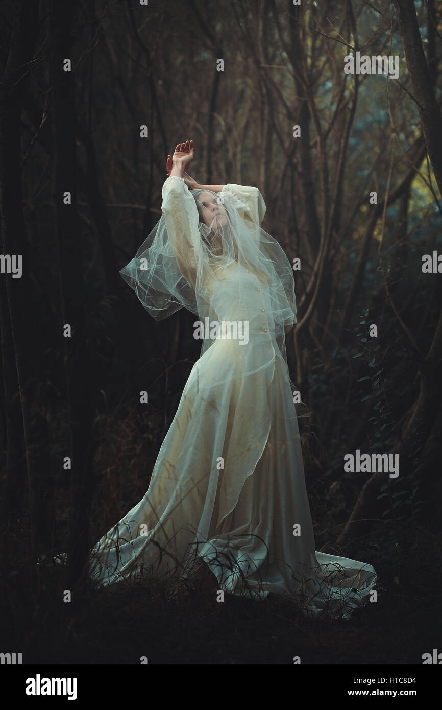 Traurige Braut mit Schleier in den Wald. Dunkel und surreal Stockfoto