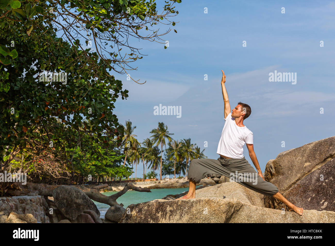 Mann am Strand, beschäftigt sich mit Sport und Yoga. Stockfoto