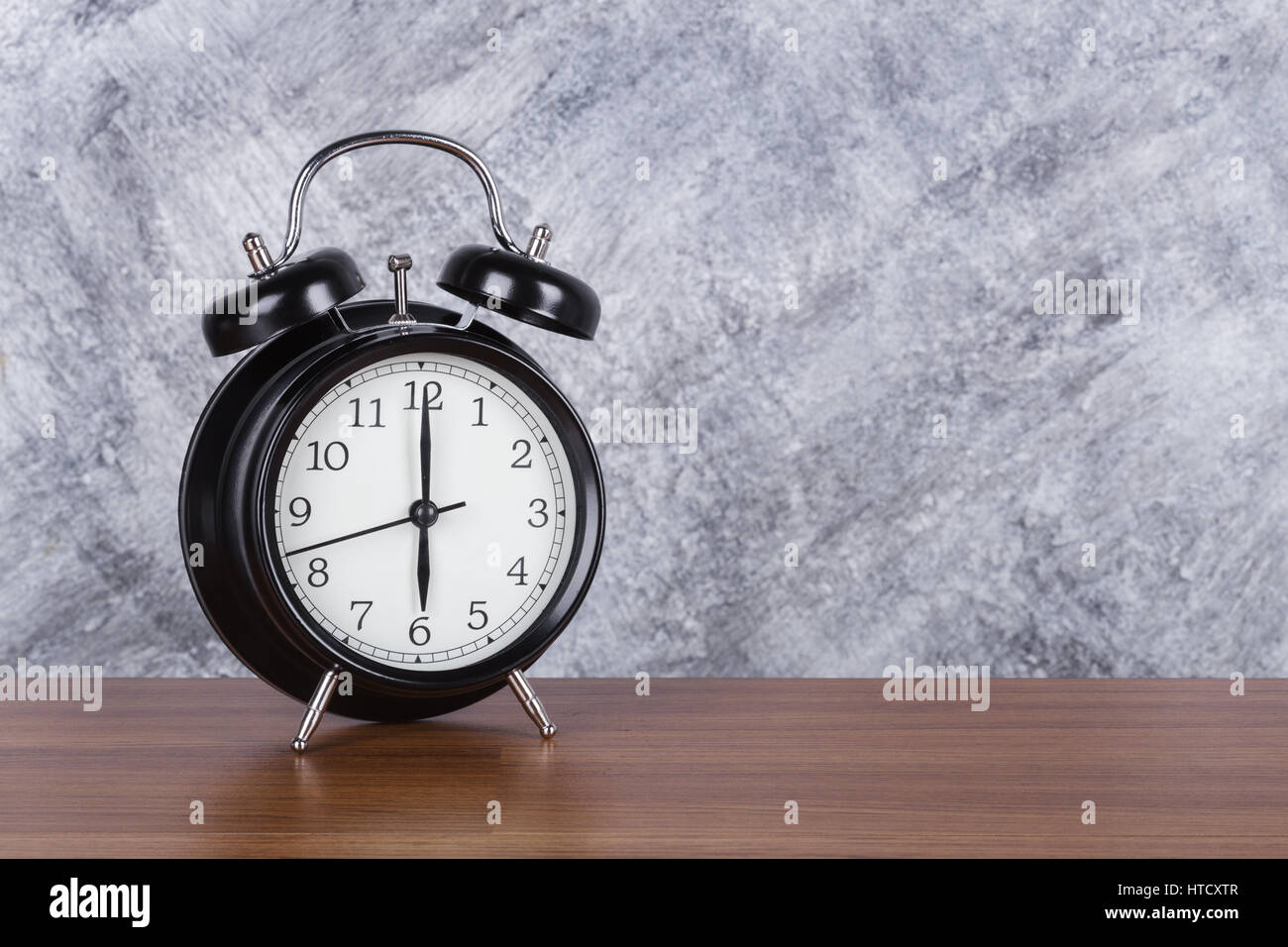 06:00 Vintage Uhr auf Holztisch und Betonwand Hintergrund Stockfoto
