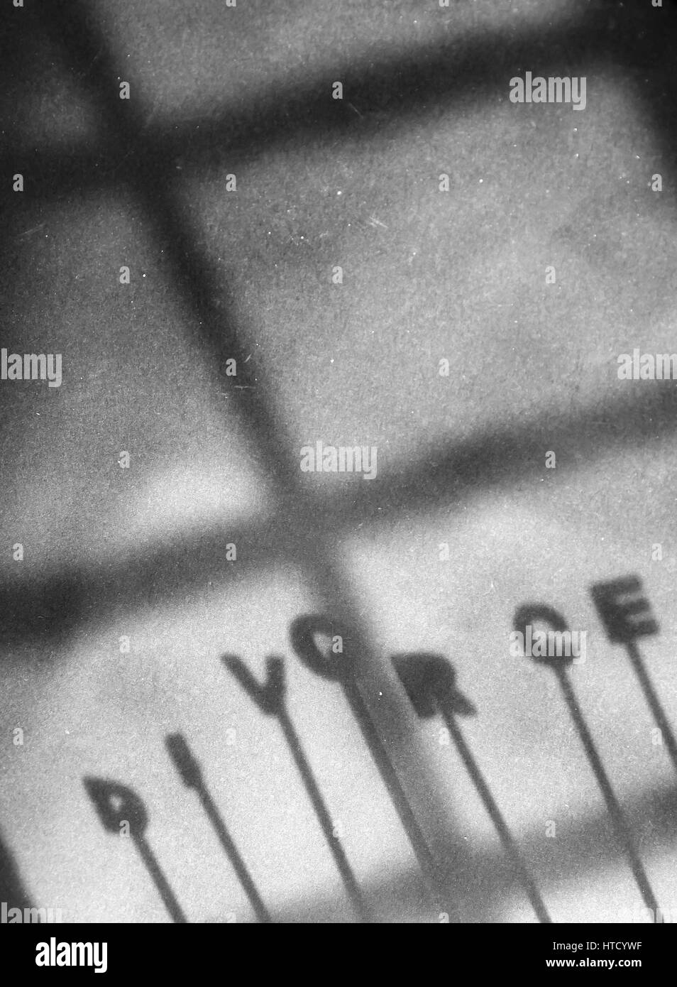 Scheidung-Hintergrund mit Schatten des Paares neben Scheidung Buchstaben auf dem Papier, Trennung Familie stellen verletzt, Mann und Frau, ist auch sozialen Status von deve Stockfoto