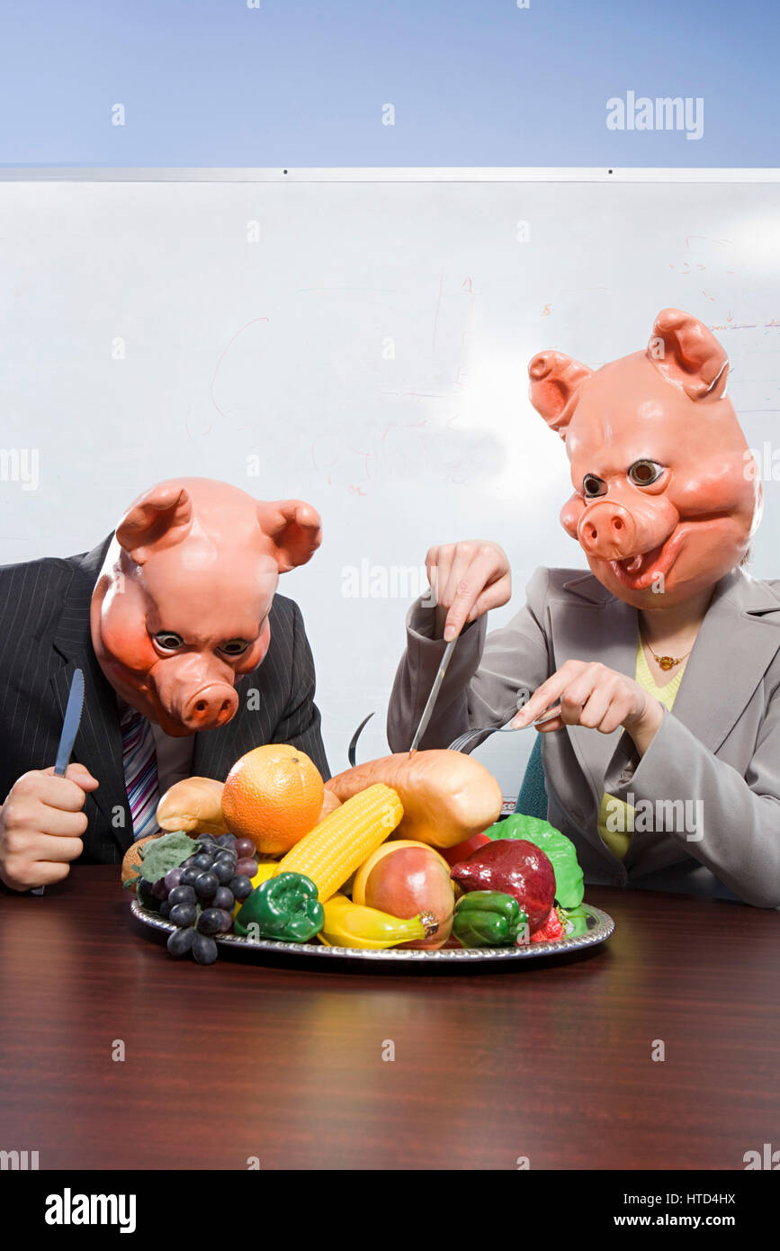 Geschäftsleute in Schwein Masken mit Kunststoff-Lebensmittel Stockfoto