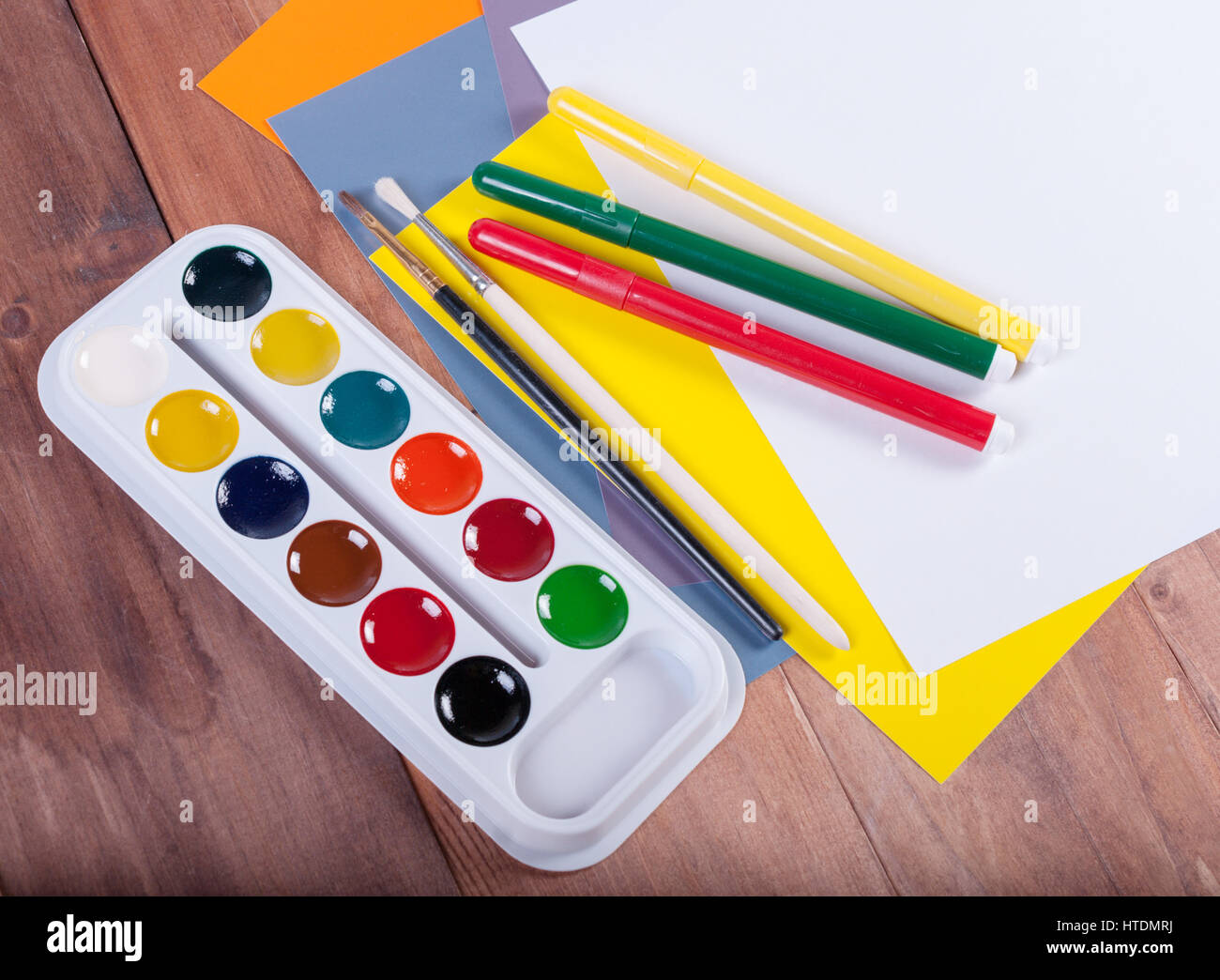 Reihe von Aquarellen, farbigen Blatt Papier und Pinsel auf einer Holzoberfläche Stockfoto