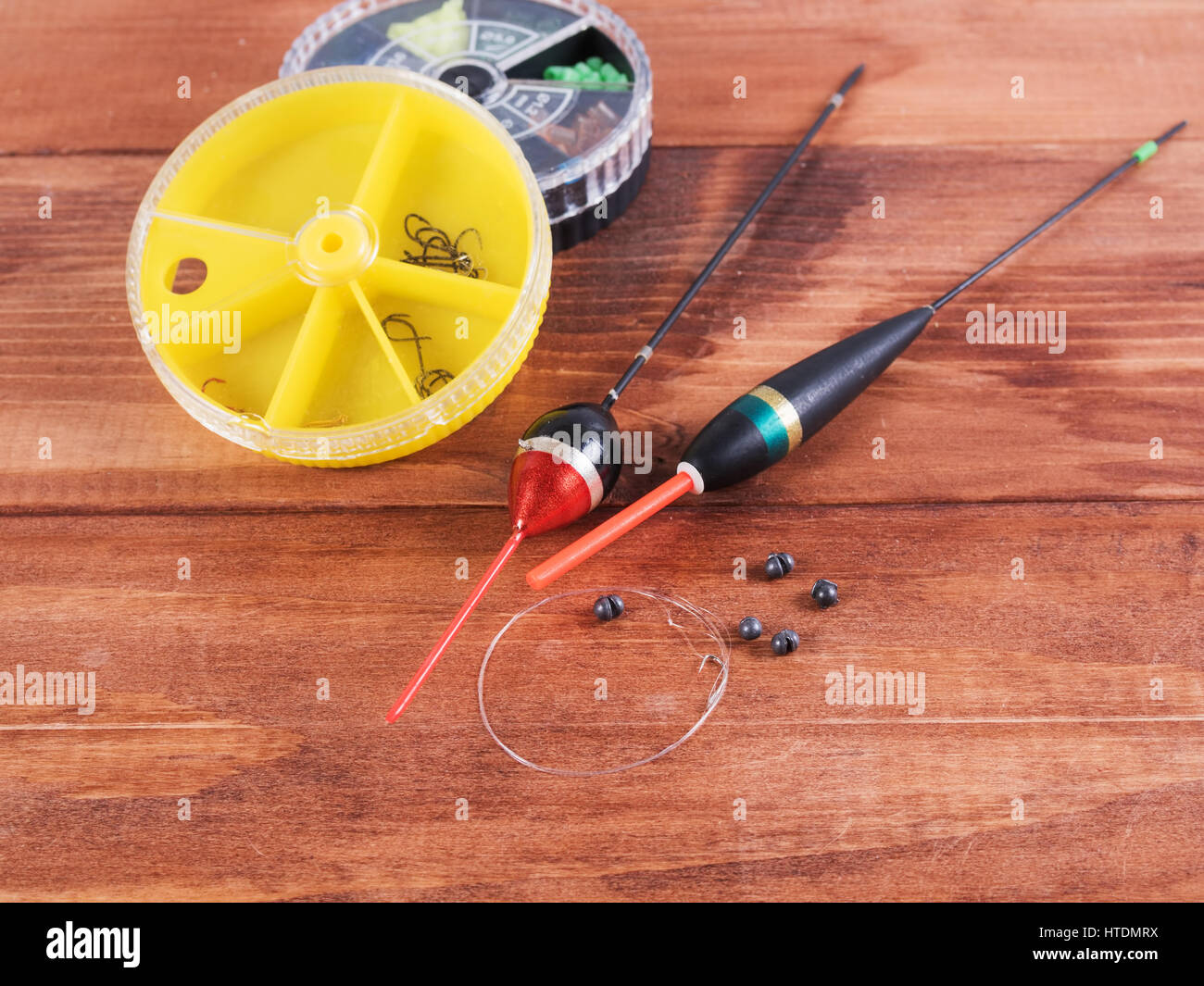 Die hin-und Herbewegungen, Platinen, Angelschnur mit Haken und kleine Runde Box auf einem hölzernen Hintergrund. Stockfoto