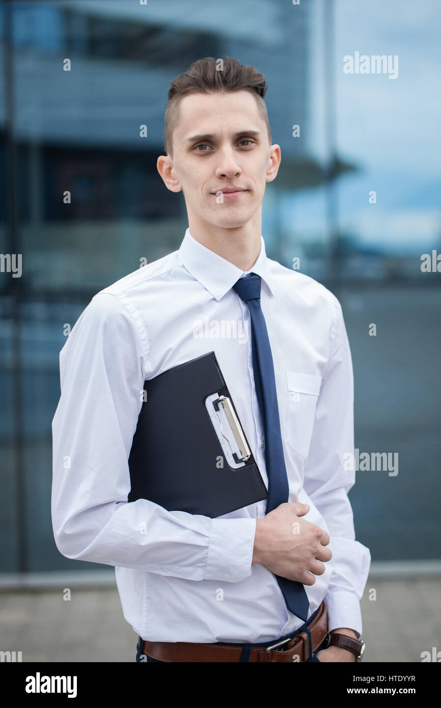 Städtische Unternehmen Mann Porträt draußen im Flughafen. Lässige jungen Geschäftsmann tragen Jackett. Hübscher Junge Manager mit in die Stadt. Stockfoto