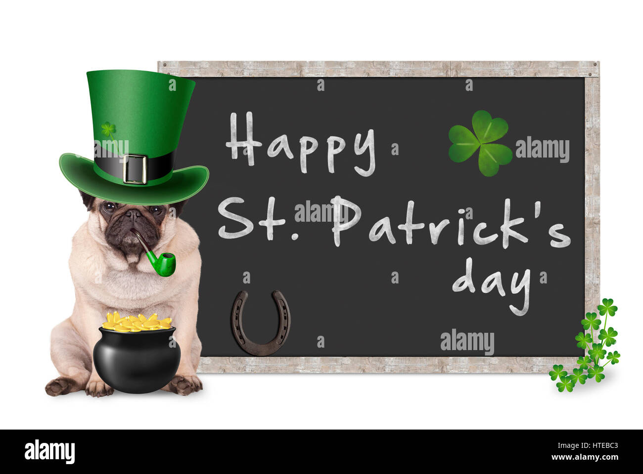 süße Mops Welpen Hund mit Kobold Hut für St. Patricks Day Pfeife, sitzt neben leere Tafel Zeichen mit Hufeisen und Kleeblatt auf weißem Stockfoto