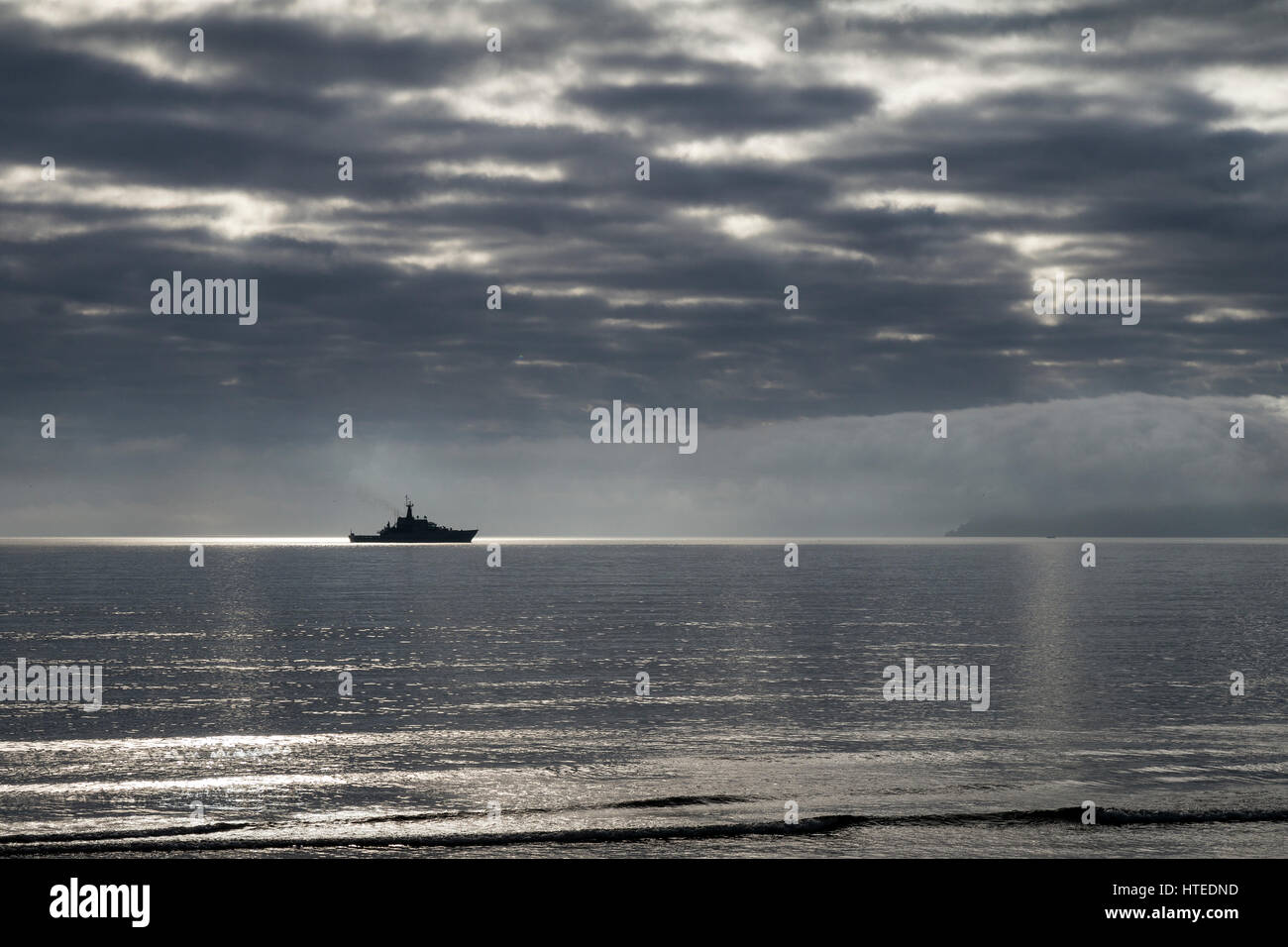 Metall Schatzsucher auf Paignton Beach Schatzsuche, sitzt ein Marineschiff in Torbay mit Berry Kopf im Hintergrund  Stockfoto