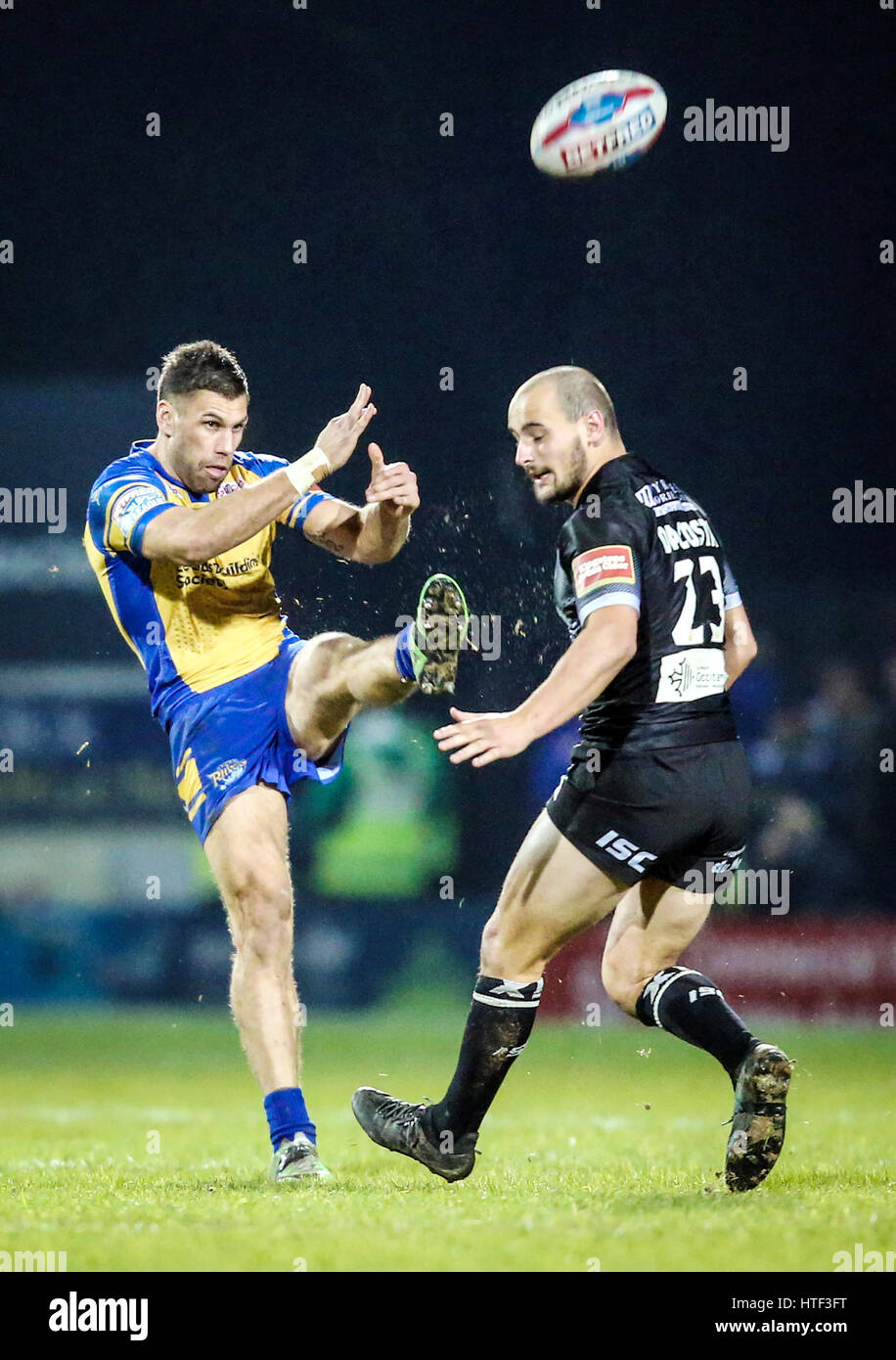 Leeds Rhinos Joel Moon kickt den Ball vorbei an Katalanen Drachen Alrix Da Costa in der Super-League-Spiel im Headingley Stadium, Leeds. Stockfoto