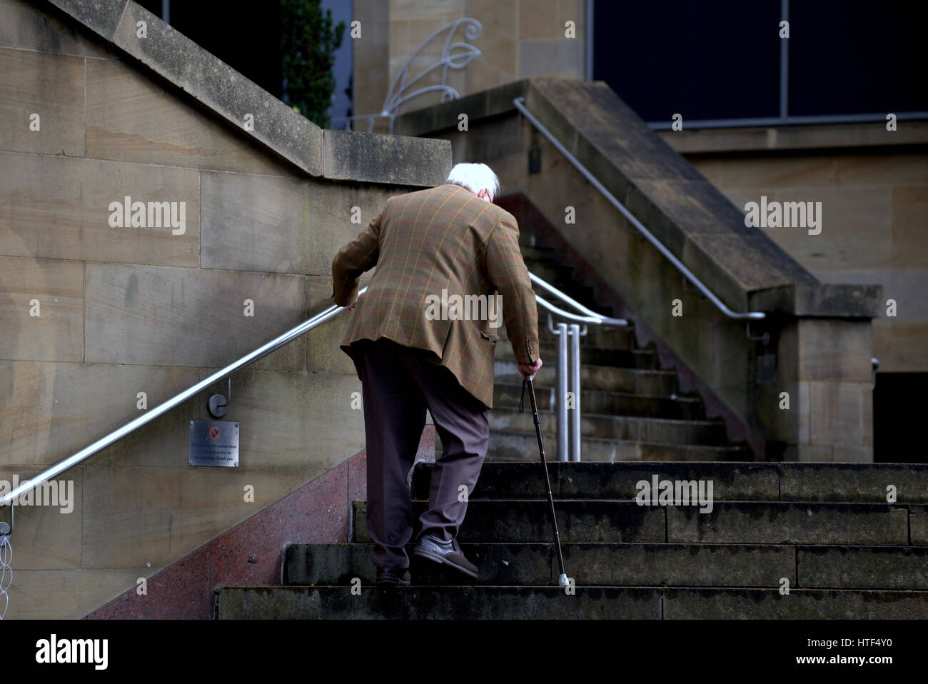 Alter Mann mit weißen graue Haare Spazierstock Treppensteigen Stockfoto