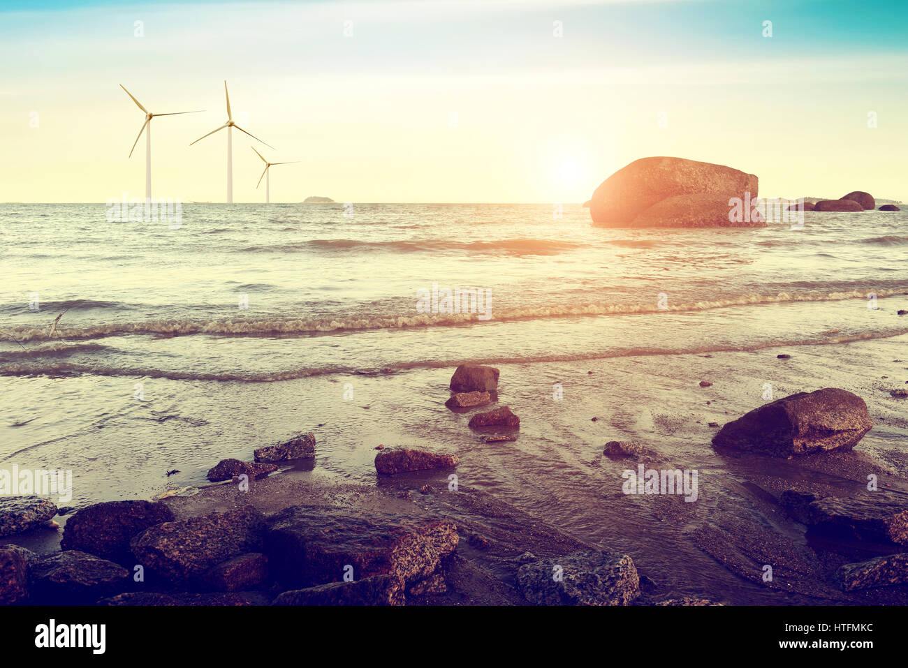 Abenddämmerung Meer, in der Nähe des Riffs und die entfernten Windturbinen. Stockfoto