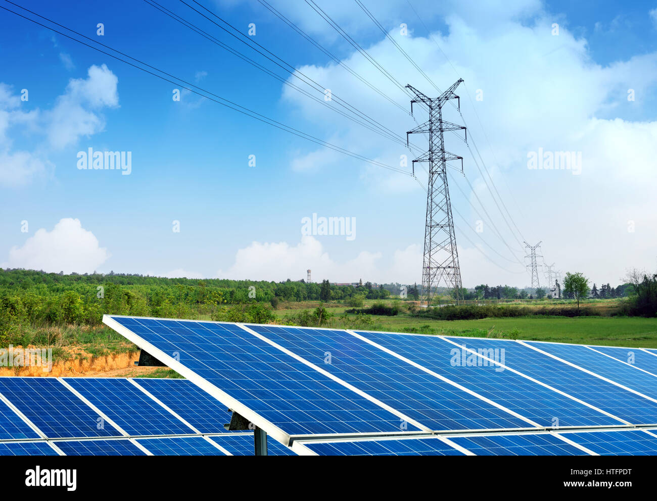 Solar-Panel mit hoher Spannung Tower im Hintergrund Stockfoto