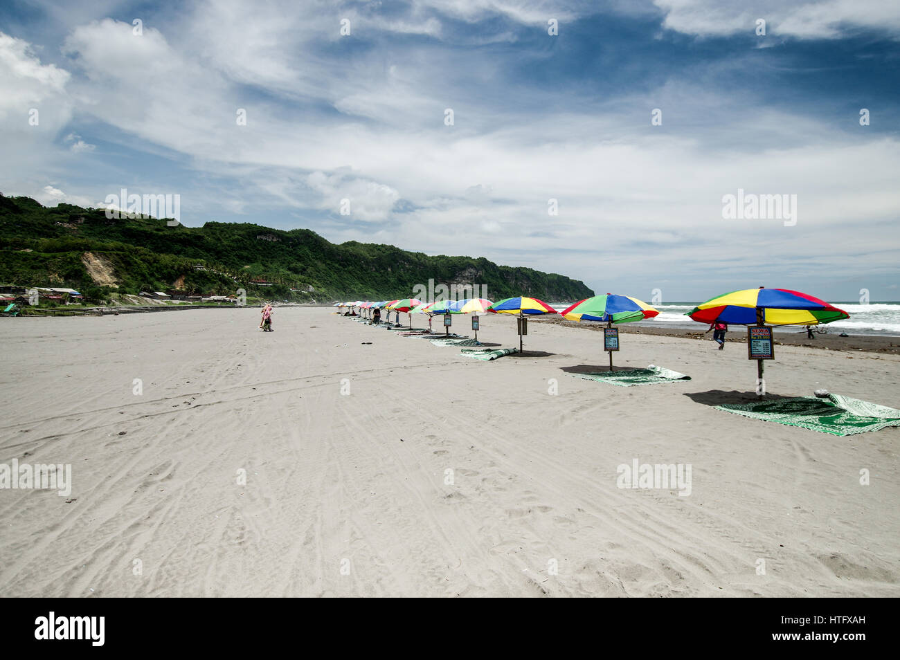 Reihe von bunten Sonnenschirmen am Strand Parangtritis in Zentraljava, Indonesien Stockfoto