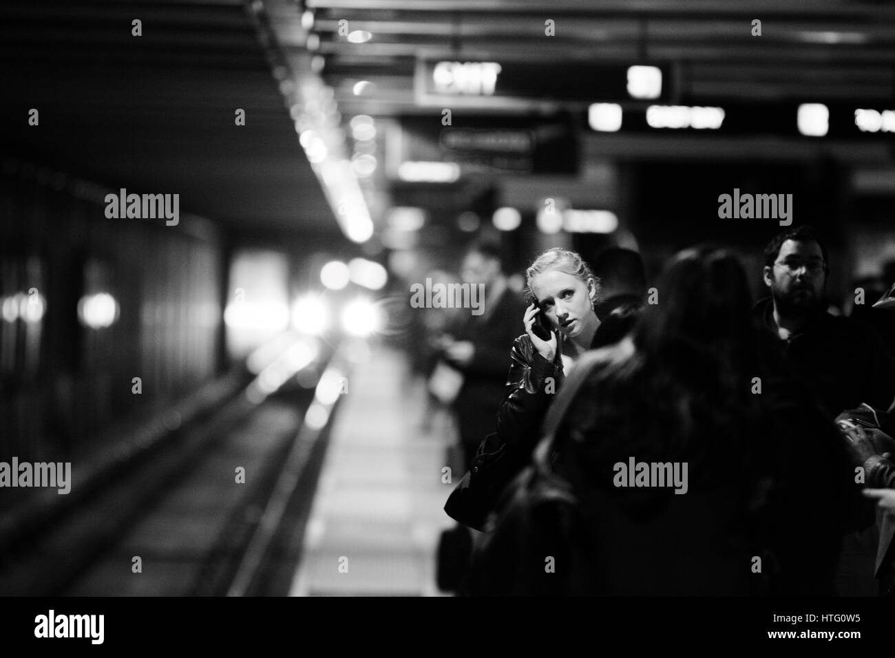 Frau stehend unter u-Bahn Pendler auf ihrem Handy sprechen. Stockfoto