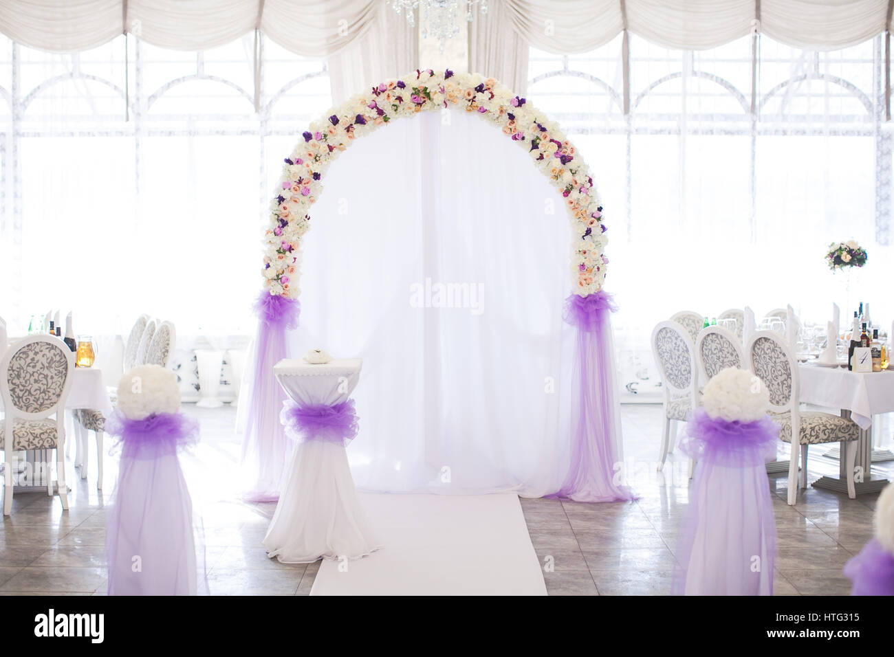 Blumenbogen aus frischen Farben für eine Trauung im Restaurant auf einem weißen Hintergrund mit einem Hochzeit-Dekor. Stockfoto