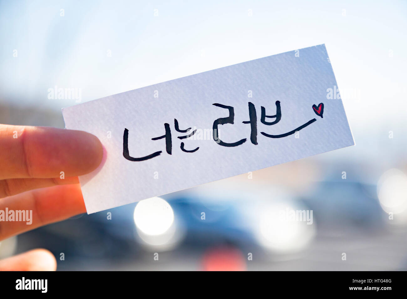 Finger halten die koreanische Kalligraphie: "Du bist Liebe" Stockfoto
