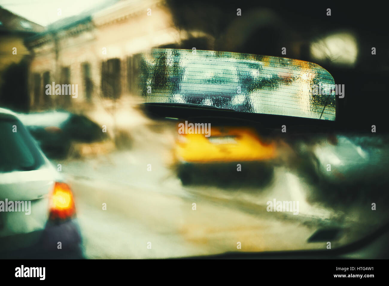 Blick vom Auto bei Regen, künstlerische unscharfen Vordergrund mit Fokus auf Rückspiegel. Stockfoto