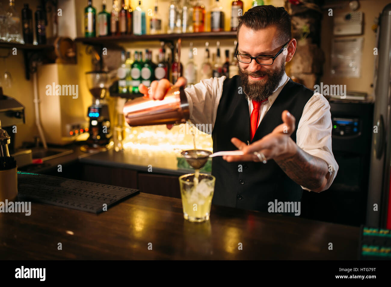 Barmann hinter Theke Abfackeln. Restaurant Regal mit Flaschen alkoholische Getränke auf Hintergrund Stockfoto