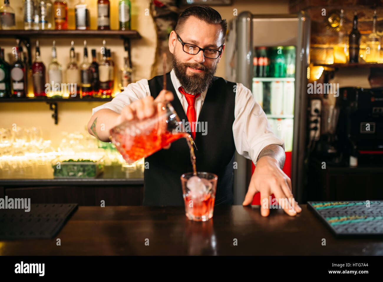 Barmann alkoholisches Getränk im Glas gießen. Barkeeper Flairing im restaurant Stockfoto