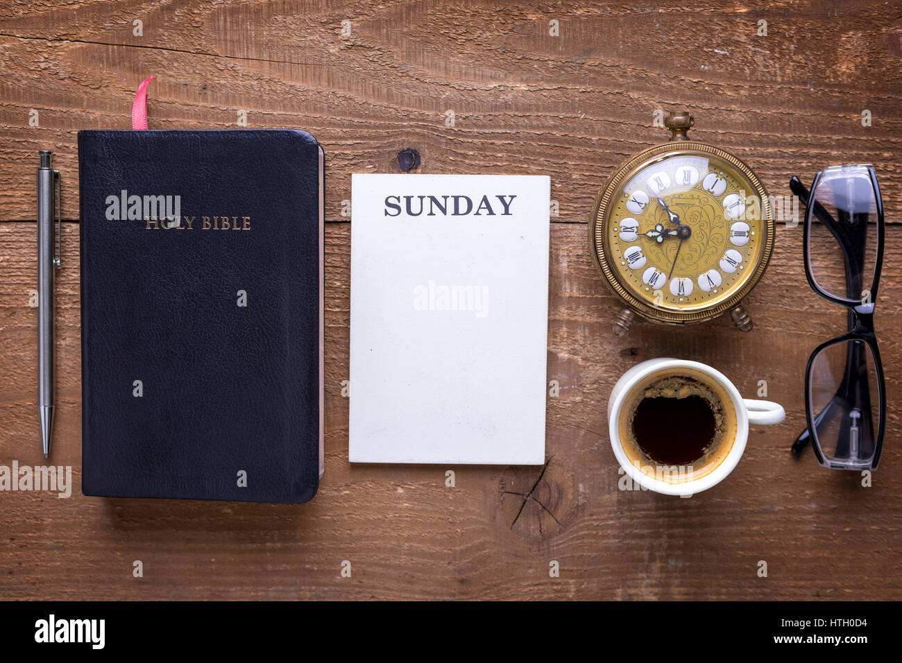 Heilige Bibel, Wecker, Gläser und Kaffee auf Holztisch. Studieren die Bibel-Konzept. Stockfoto