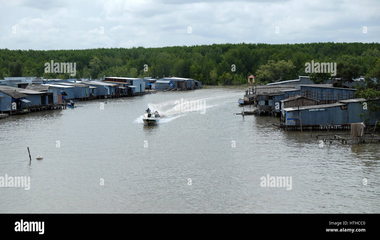 Erstaunliche Szene auf Wasserstraße im Mekong-Delta, Vietnam. Motorboot auf Ca Mau Fluss schnell einziehen, Motorboot machen Wellen auf dem Wasser, Flussufer mit Wohn- Stockfoto