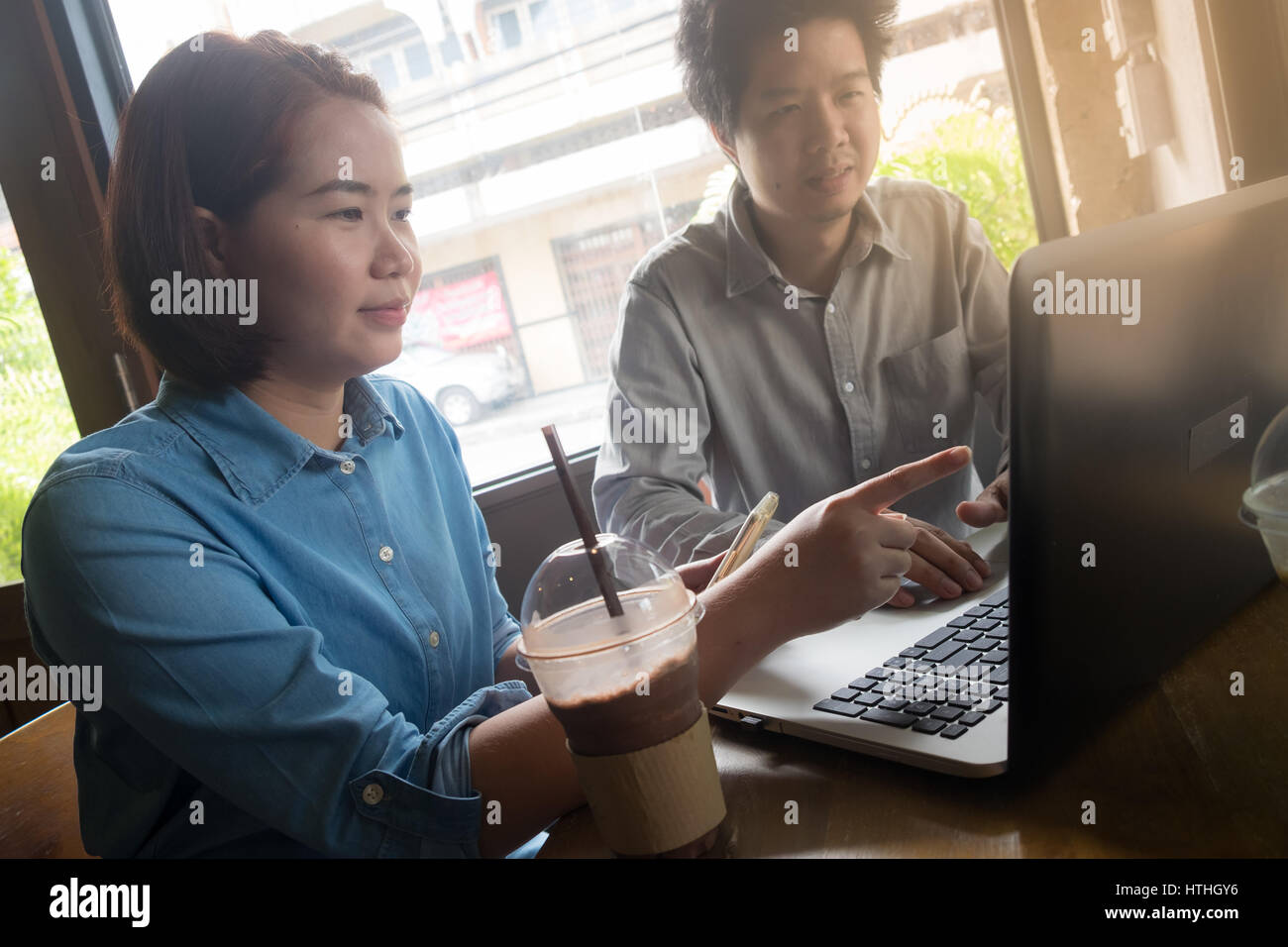 Junge Hipster Frau zeigte auf Laptop-Bildschirm. Freie Mitarbeiter teilen ihre Ideen während der Arbeit zusammen mit Laptop im Café. Brainstorm-bus Stockfoto