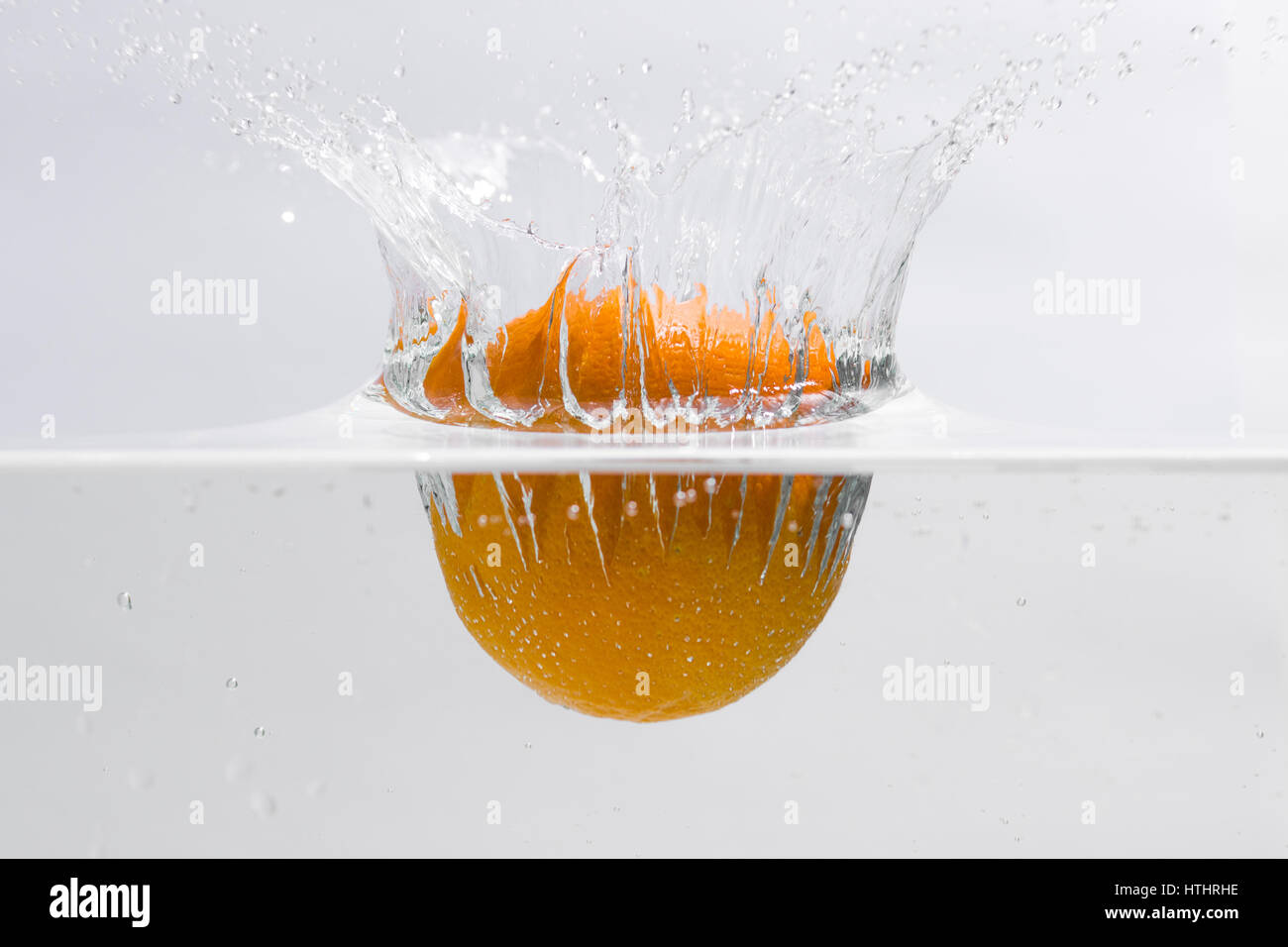 Eine Orange fallen ins Wasser, macht einen Sprung Stockfoto