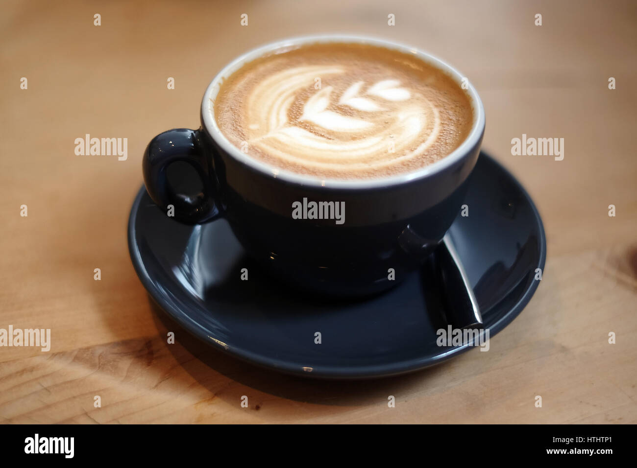 Flache weiße Kaffee in einem Restaurant, auf einem Holztisch Stockfoto